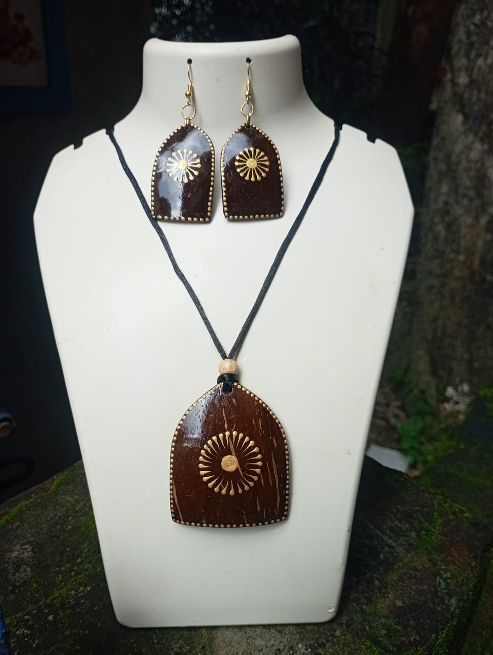 Jewelry set with pendant necklace and earrings on a mannequin bust.