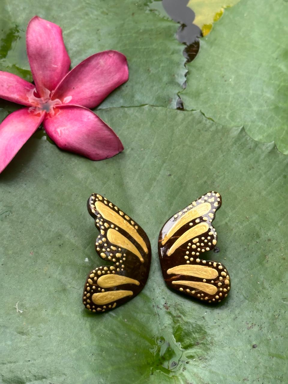 Butterfly-shaped earrings with gold and black design in the leaf.