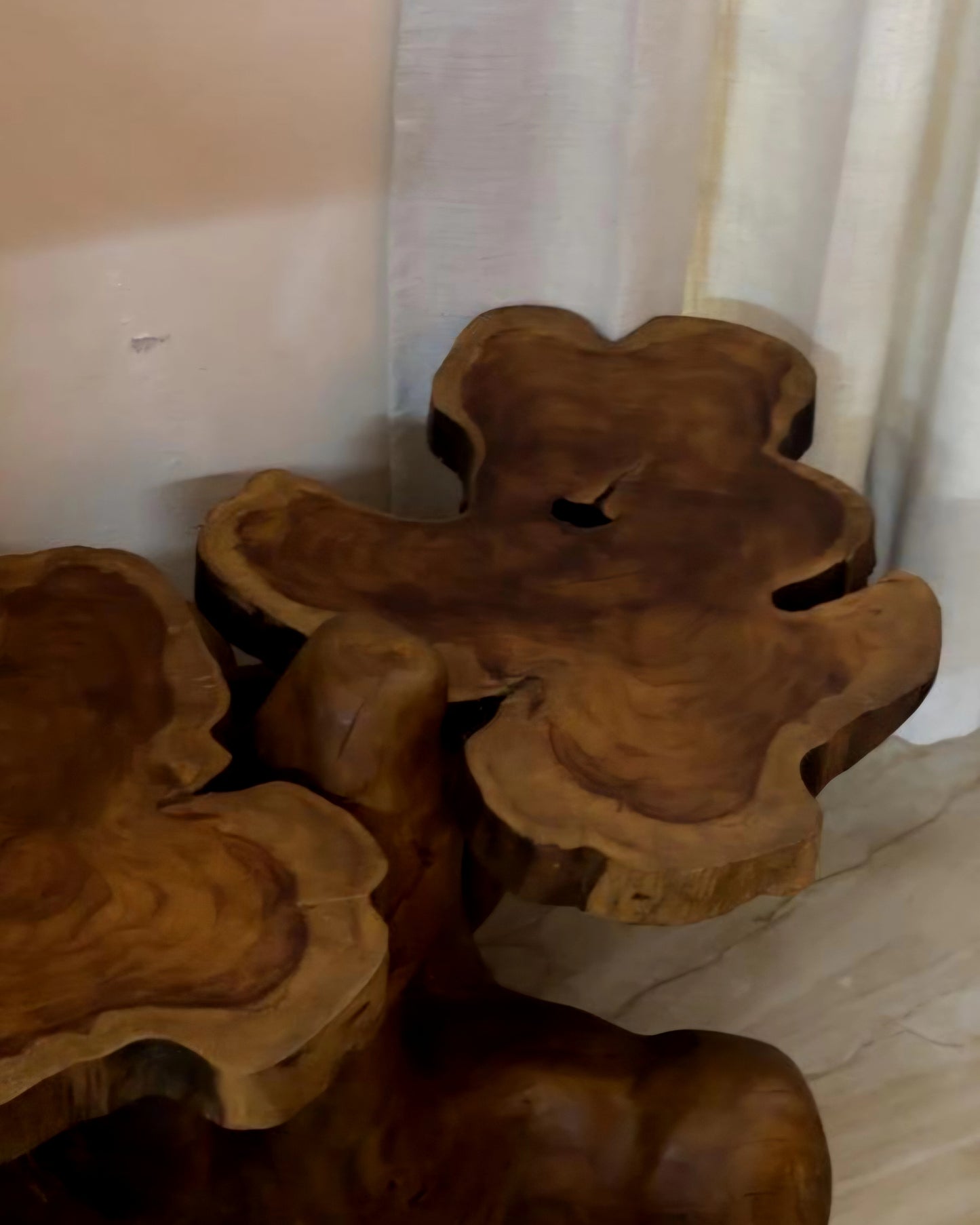 Wooden root sculpture on a marble floor with a neutral wall background