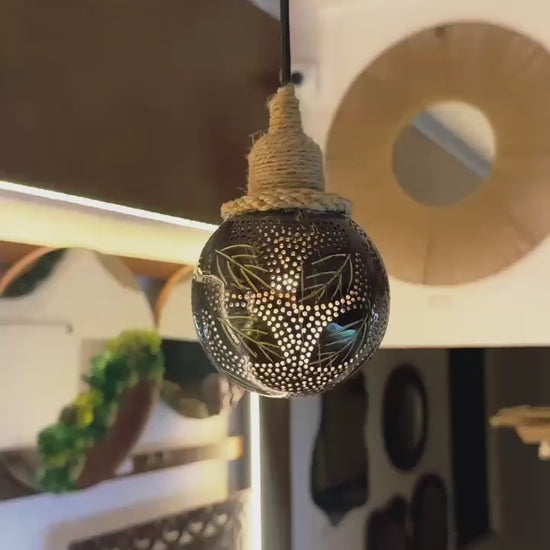 Decorative light bulb with intricate patterns hanging from a ceiling.