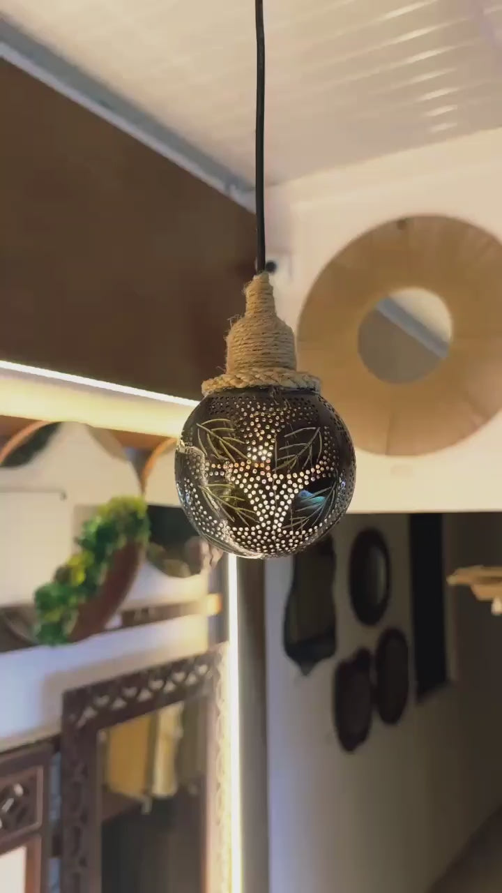 Decorative light bulb with intricate patterns hanging from a ceiling.
