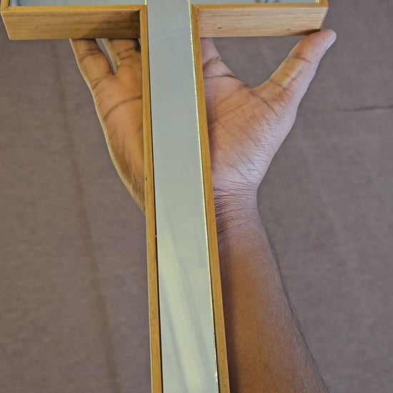 Decorative cross with glass panels on a wooden wall