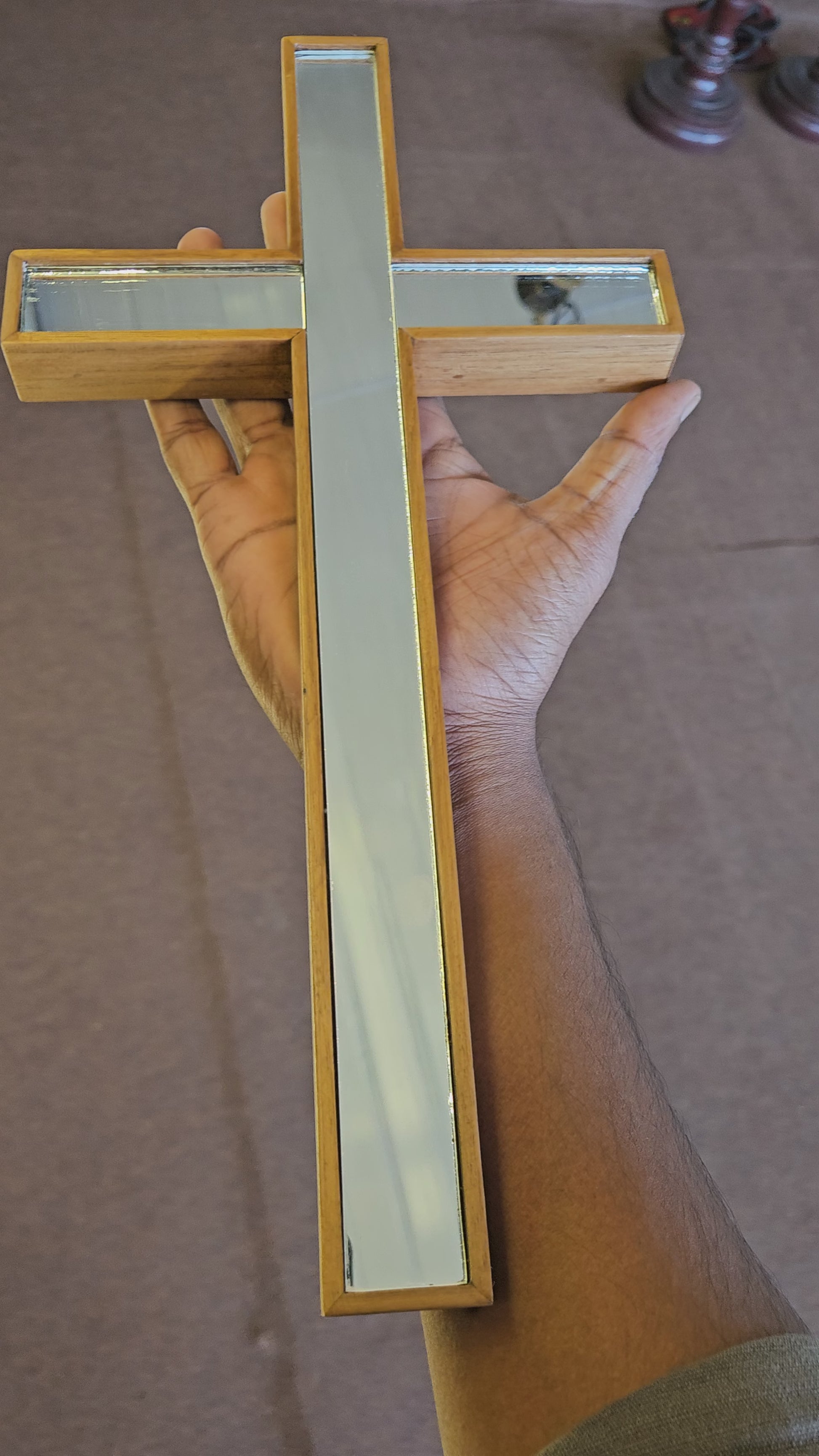 Decorative cross with glass panels on a wooden wall