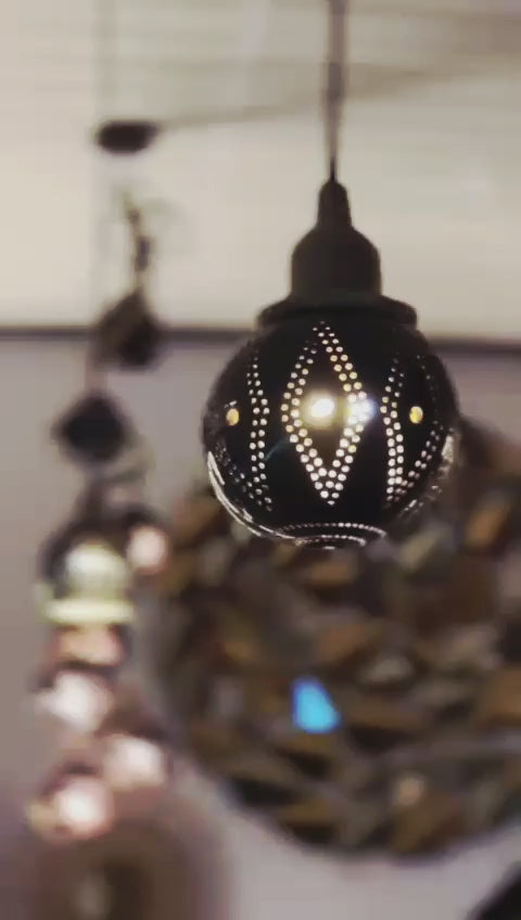 Decorative black lamp with intricate patterns hanging indoors.
