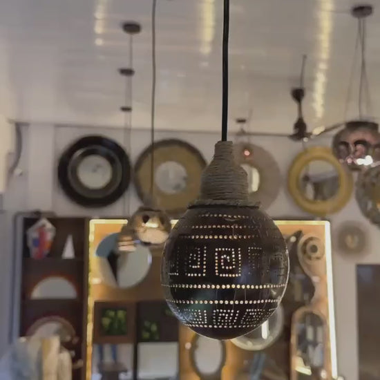 Decorative light bulb with intricate design hanging against a blurred background