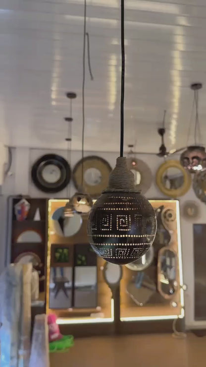 Decorative light bulb with intricate design hanging against a blurred background