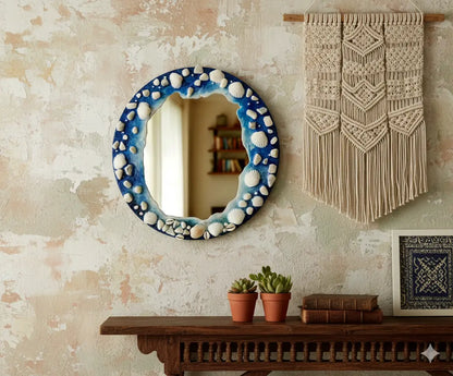 Decorative mirror with shell accents on a textured wall above a wooden console table.