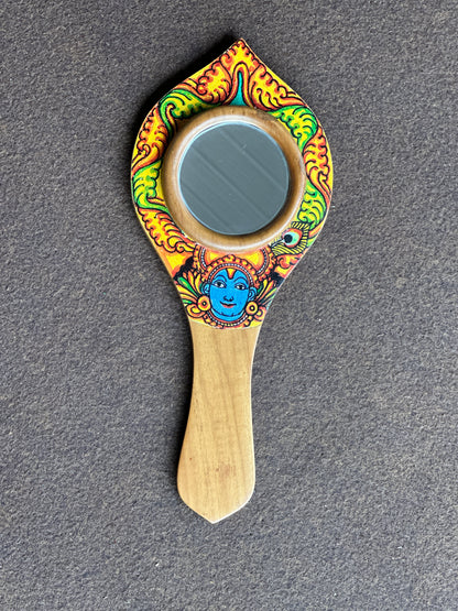 Decorative hand mirror with colorful design on a gray background