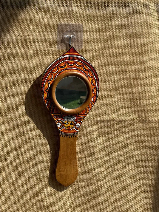 Decorative hand mirror with wooden handle on a textured beige background