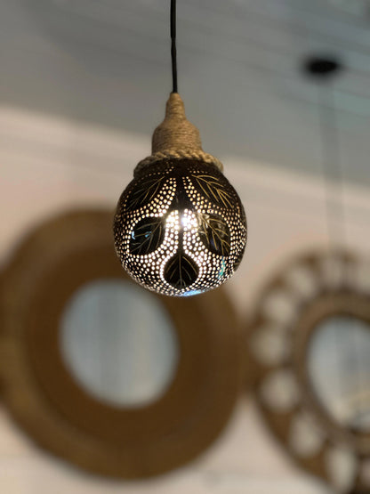 Decorative light bulb with intricate patterns hanging from a ceiling.