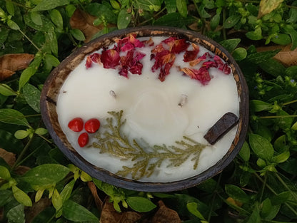 Candle in a coconut shell with natural elements on a grassy background