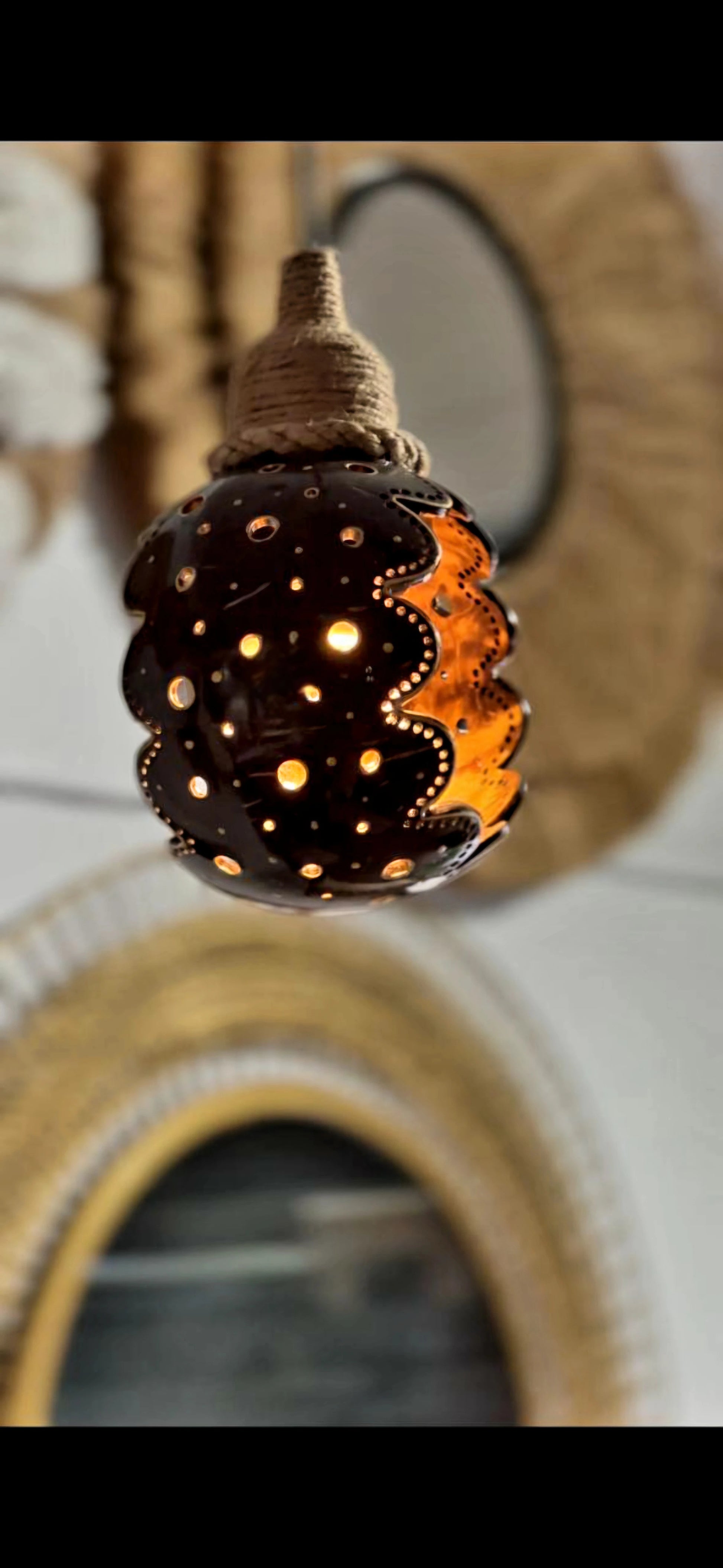 Decorative lamp with a textured surface and glowing interior, set against a blurred background.
