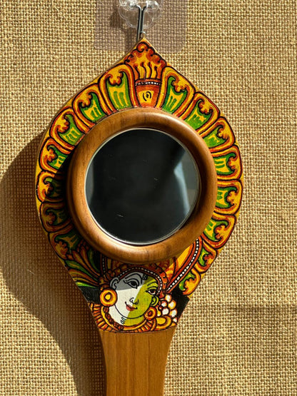 Decorative hand mirror with colorful patterns on a beige background