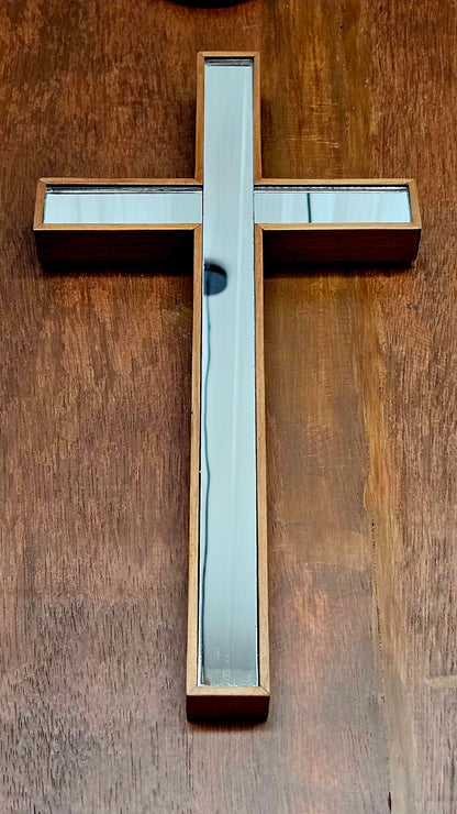 Wooden cross with glass panels on a wooden background
