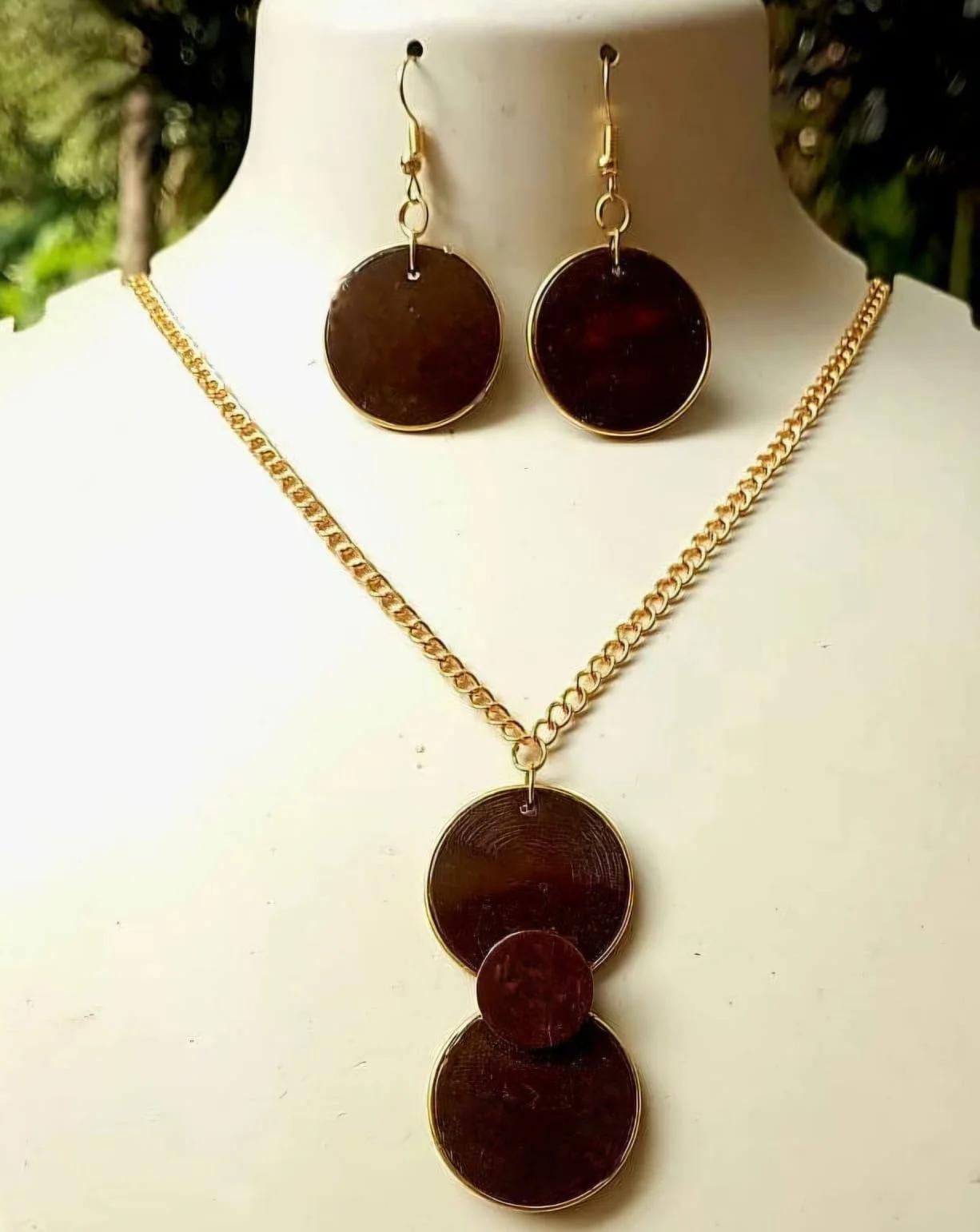 Jewelry set with pendant necklace and earrings on a mannequin.