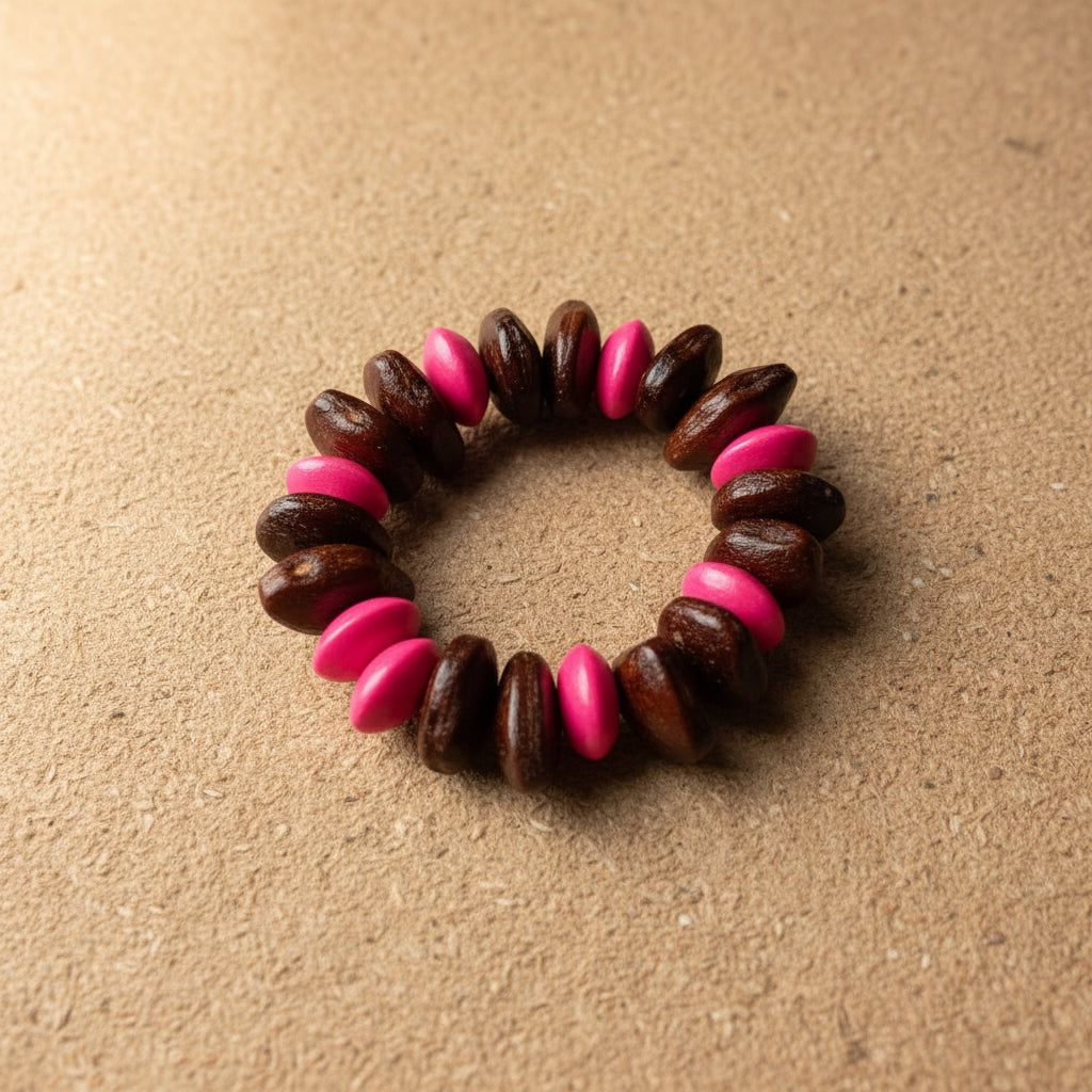 Beaded hair tie with pink and brown beads on a textured gray background