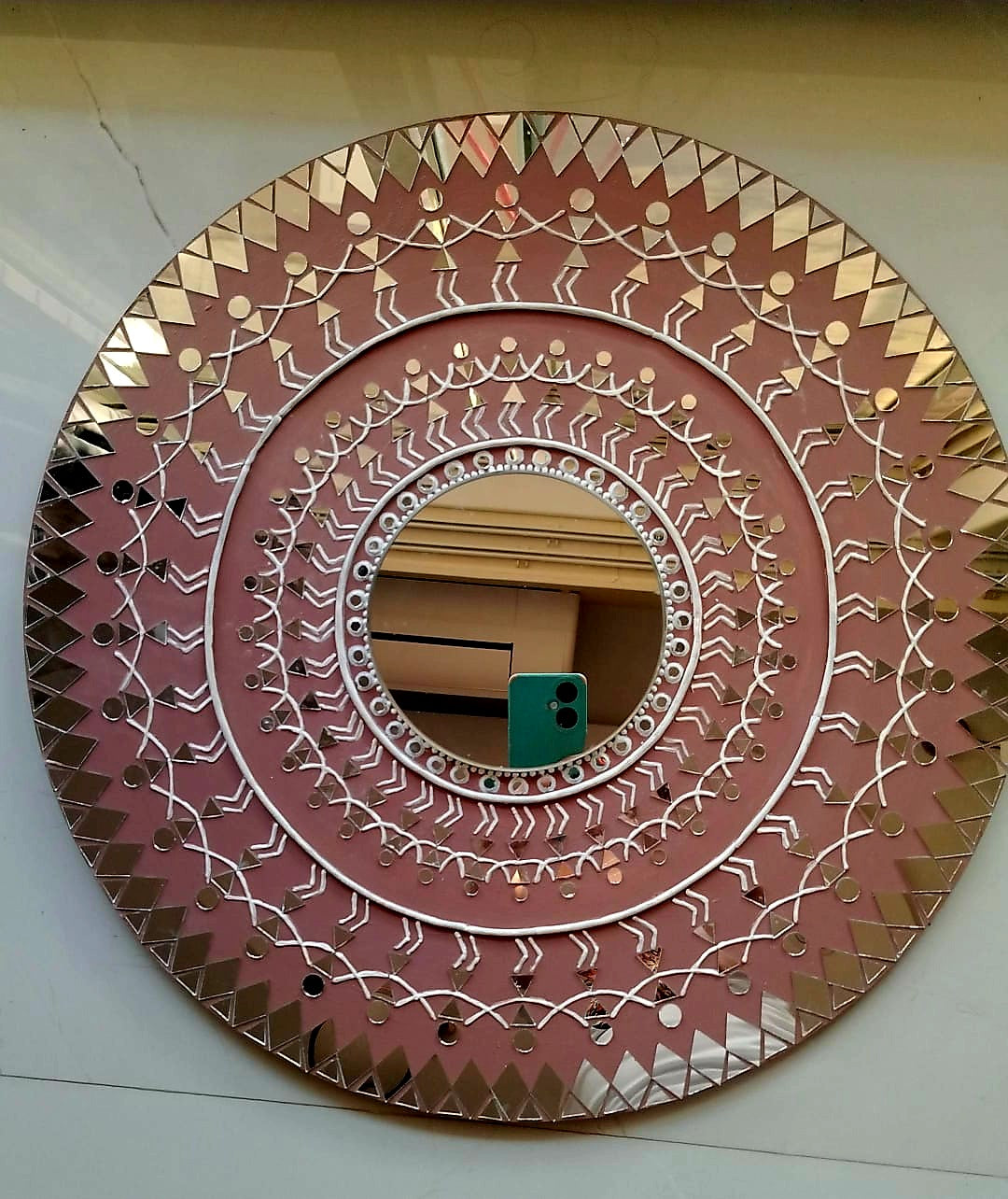 Decorative circular mirror with geometric patterns on a white background