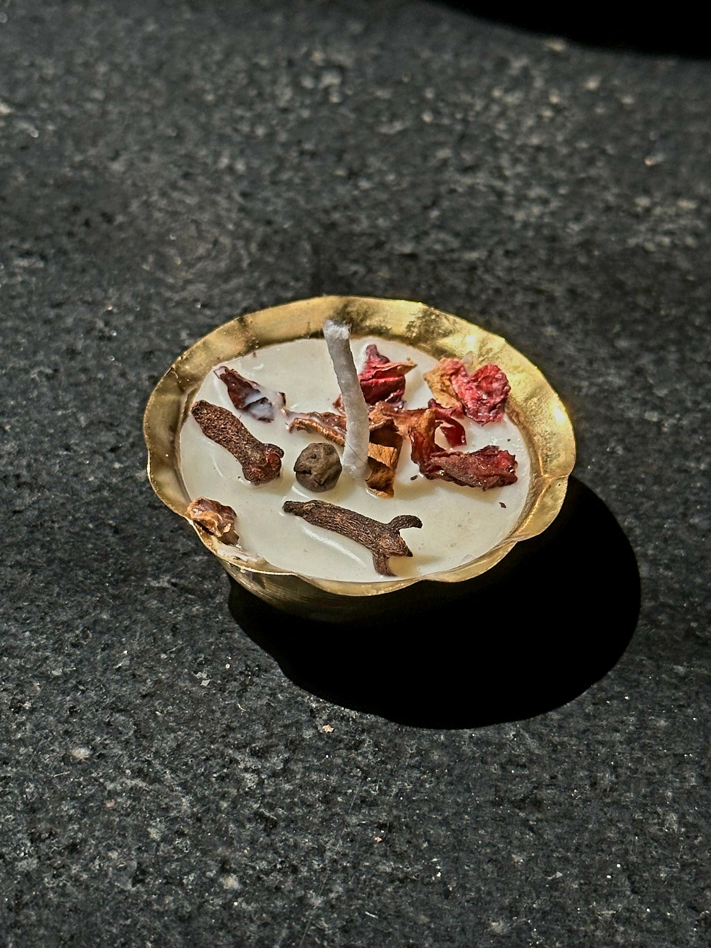Candle with decorative elements on a dark surface