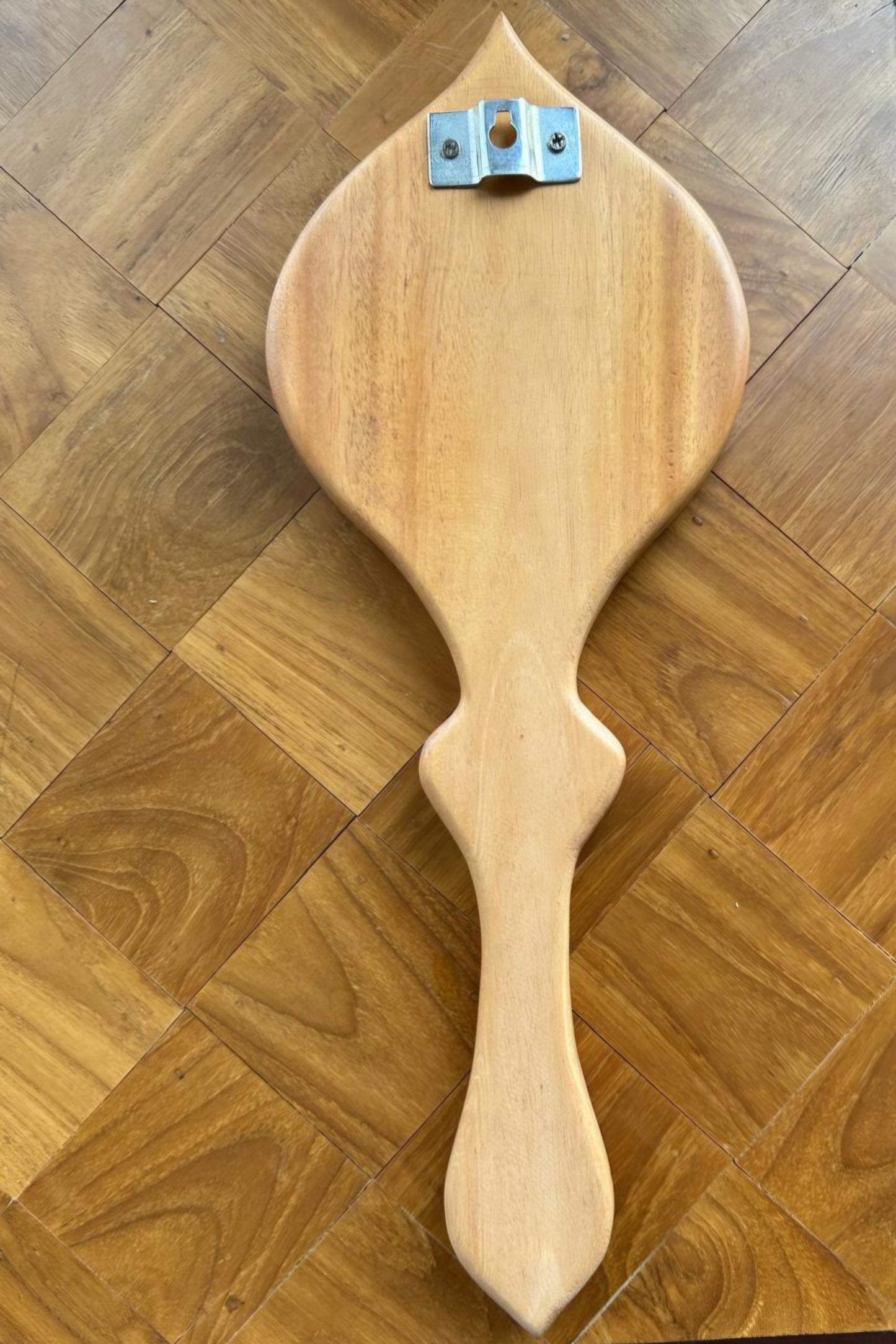 Wooden paddle with a handle on a wooden floor