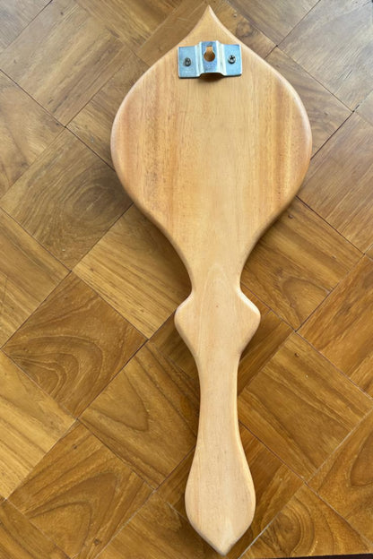 Wooden paddle with a handle on a wooden floor