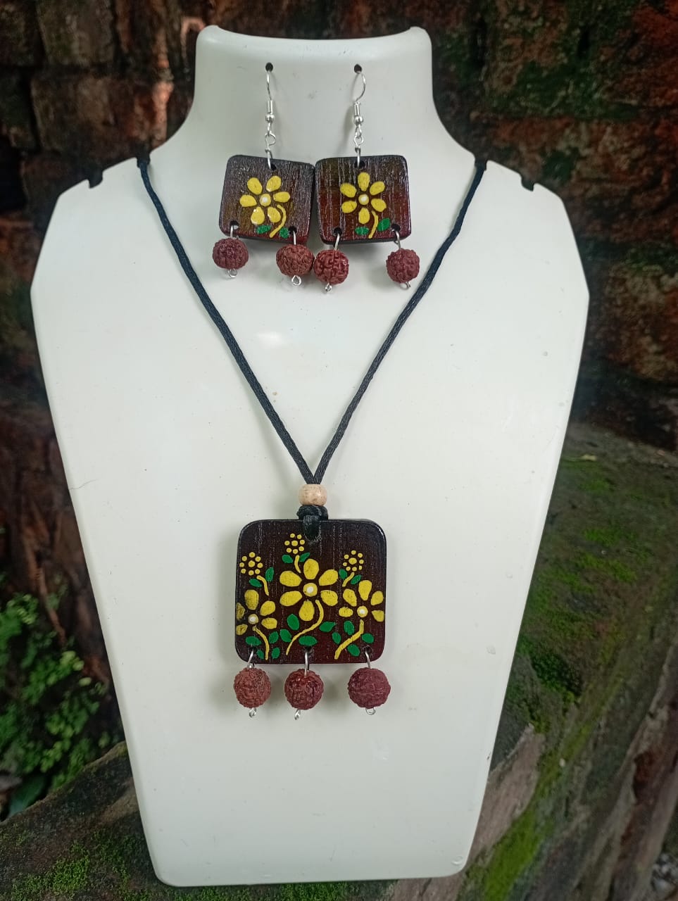 Jewelry set with pendant and earrings on a white mannequin bust.