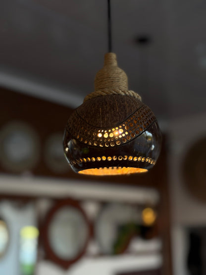 Decorative pendant light with a textured design hanging against a blurred background