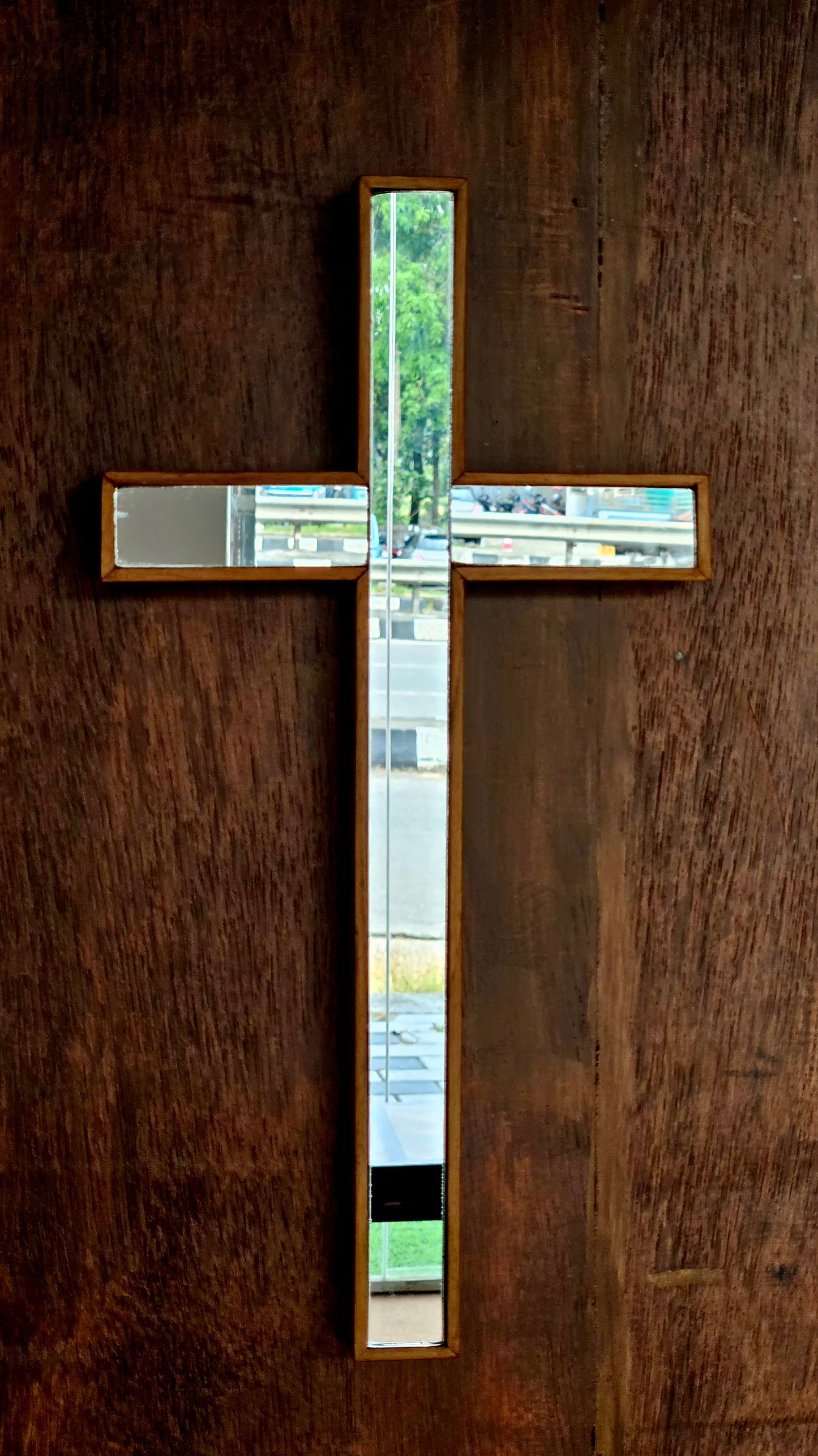 Decorative cross with glass panels on a wooden wall