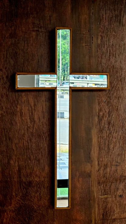 Decorative cross with glass panels on a wooden wall