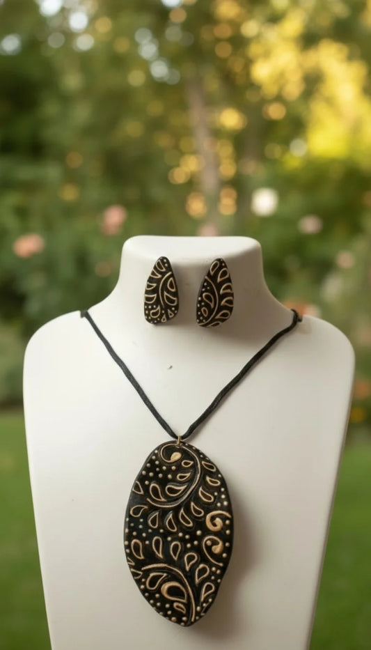 Jewelry set with a necklace and earrings on a mannequin bust against a blurred natural background.